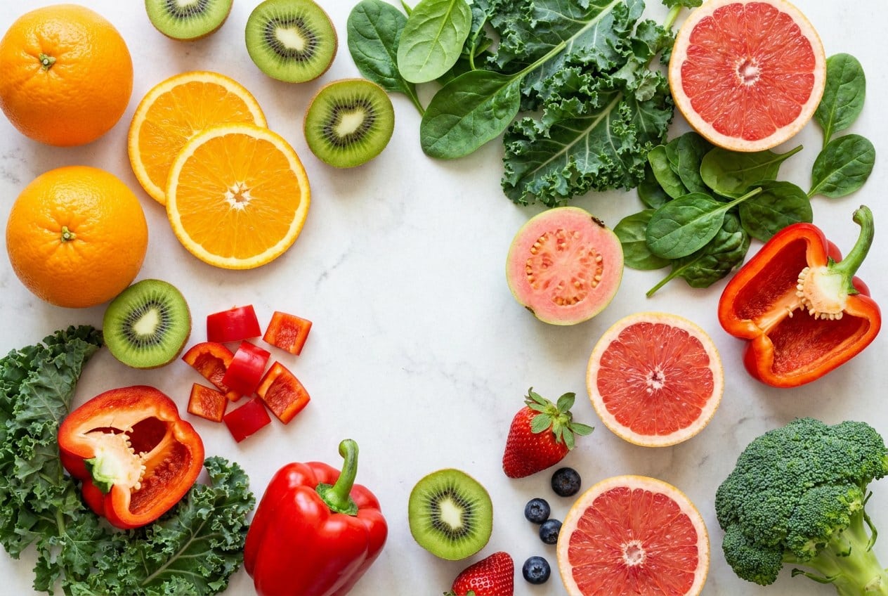 Vitamine C rijke voeding zoals sinaasappel, kiwi en paprika die collageen ondersteunt